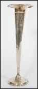 An early 20th century sterling silver tall vase raised on a circular base with trumpet column and
