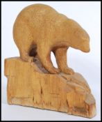 A 1920's wooden carved polar bear figurine depicting a polar bear on an iceberg. Measures 24cm-high.