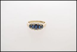 A  hallmarked 9ct gold sapphire and diamond ring having 5 graduated marquise cut blue sapphires with