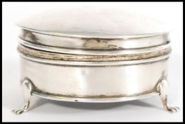 An early 20th century silver hallmarked dressing table pot of round form, raised on three feet