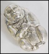 A 20th century silver plated vesta in the form of a monkey with fruit. Weight 53.8g. Measures 6 cm