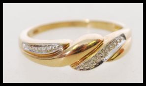 A hallmarked 20th century 9ct gold and diamond ring with a twist design and inset diamonds.