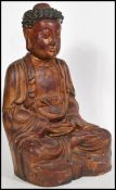 A large Chinese plaster lacquer painted sculpture of a deity sat in the lotus position having red