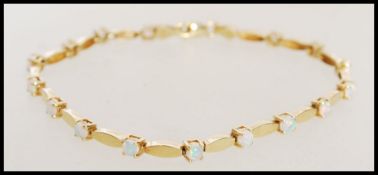 A stamped 585 14ct gold spacer bracelet with prong set opals. Weight approx 6.2g. Length approx