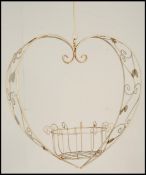 A vintage / retro 20th Century wire work heart shaped hanging planter, the scroll work frame adorned