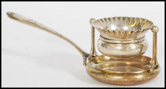 A silver Continental early 20th Century tea ball strainer on a pivot stand, with drip tray to the