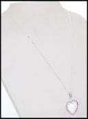 A stamped 925 silver pendant necklace with a heart shaped pendant with inset opal pane and purple