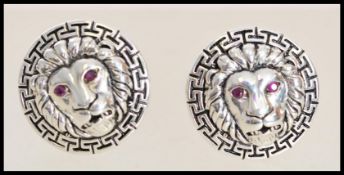 A pair of stamped sterling silver cufflinks in the form of lions with red stone eyes. Weight 2.1g.