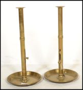 A pair of large 19th century Ecclesiastic brass ejector candlesticks raised on large circular