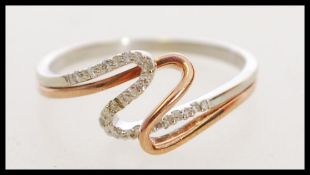 A hallmarked 9ct white, rose gold and diamond crossover ring. Hallmarked London. Weight 1.8g. Size