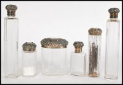 A collection of late 19th century Victorian cut glass and silver hallmarked vanity table bottles