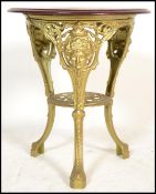 A Victorian style cast iron pub / tavern table with cast gilt iron base and wooden mahogany  top.