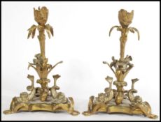 A pair of 19th century Victorian brass candlesticks, with decorative fish and birds on a