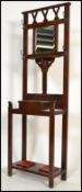 A 1920's dark oak hallstand with central glove drawer having mirror upright with coat hooks and