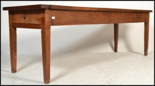 A large 19th century French solid heavy oak two plank refectory dining table being raised on