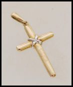 A yellow metal crucifix pendant. Weight 0.8g. Measures 3 cm high and 1.5 cm wide.