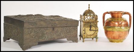 A Japanese metal box having ornate peony embossing to the lid and sides on four feet with a hinged