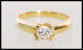 A stamped 750 18ct yellow gold and diamond solitaire ring having a single prong set round