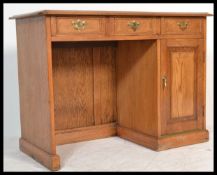 A 20th century golden oak Georgian revival writing table kneehole desk having a series of drawers to