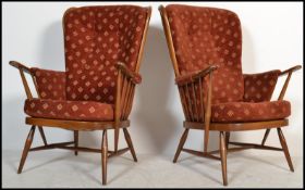 A pair of vintage retro 20th century Ercol beech and elm wing back spindle back armchairs raised