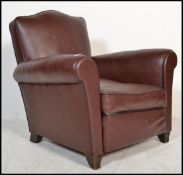 A mid century French burgandy leather club chair  - armchair being raised on block feet with