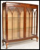 A 1920's mahogany china display cabinet / bookcase having claw and ball feet with twin astragal