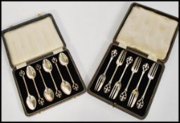 A cased set of silver hallmarked teaspoons, surmounted with a Fleur De Lys fret pierced finial,