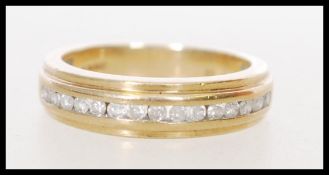 A hallmarked 20th century 9ct gold ring with channel inset 25 pts of diamonds. Weight 3.6g. Size L.