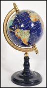A vintage 20th century lapis lazuli desk top globe having precious stone inlay raised on a