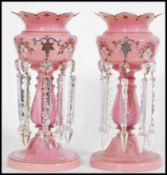 A pair of 19th century Victorian pink glass lustres with with crenelated rims, having seven
