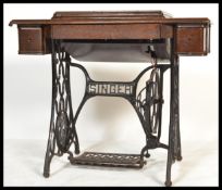 A Victorian mahogany and cast Iron singer sewing machine treadle table. The base with decorative