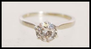 A stamped 14k white gold diamond solitaire ring with a prong set round brilliant cut diamond.