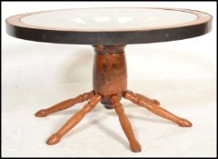 A retro mid century coffee table in teak being formed from a ships wheel having an inset glass top