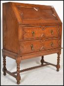 A 1920's golden oak bureau desk being raised on barley twist legs united by stretchers. Geometric
