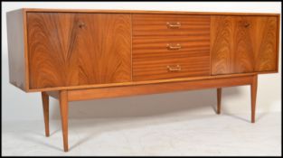 A mid 20th century long and low teak Uniflex sideboard fitted with a central tower of three