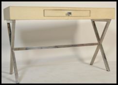 A 20th Century faux lizard skin side table, raised on chrome cross support frames united by a single