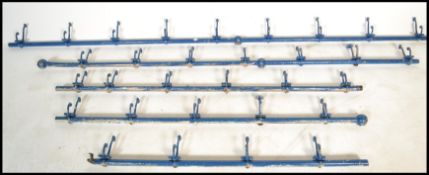 A collection of 19th Century Victorian industrial steel and brass coat hooks on rail. The rail being
