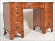A Georgian revival 20th century bow fronted twin pedestal writing table desk in yew wood with tooled
