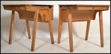 A pair of mid 20th Century school / students desks, lift up top with storage below raised on bent