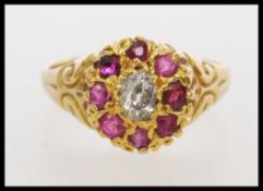 An 18ct gold ruby and diamond ring set with a central oval old cut diamond (approx 6mm x 4mm)