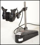 A vintage mid century opticians eye glass magnifier lamp by Cooke & Yorke. Ebonised with weighted