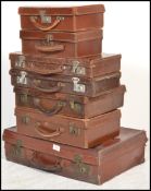 A selection of vintage 20th Century suitcases, majority covered with leather, all with locks and