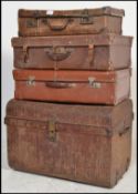 A stack of vintage 20th Century trunks and suitcases,to include two tin trunks with brass clasps and