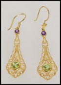 A pair of Art Deco style stamped sterling silver yellow metal earrings with inset green and purple
