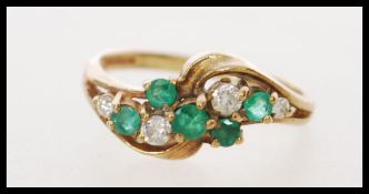 A 9ct hallmarked gold ring with green stones and four 17 pts of white stones set in a symmetrical