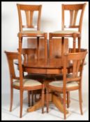 A 20th century French Cherry wood circular extending dining table together with a set of 6