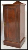 An Edwardian mahogany pot cupboard having plinth base with locker door and open recess with shaped