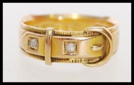 A hallmarked Victorian 15ct gold buckle band ring being set with two rose cut diamonds. Hallmarked
