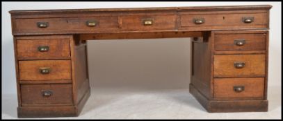 An early 20th century, circa 1920's  oak industrial office twin pedestal partners desk. Raised on