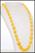 A vintage 20th century imitation amber necklace with large oval beads. Measures 63 cm long.